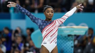 Simone Biles lands the vault at the Paris 2024 Olympic Games gymnastics, wearing a Team USA white and blue leotard.