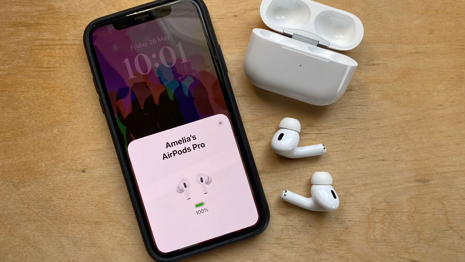 An iPhone next to the AirPods Pro 2