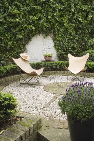 A small gravel garden with two outdoor chairs