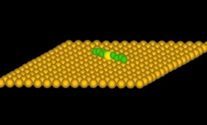 In this computer generated image, a single, targeted molecule (gold, center) powered by an electrical current rotates on a metal surface.