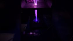A close up of a blue laser in a dark room.