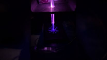 A close up of a blue laser in a dark room.