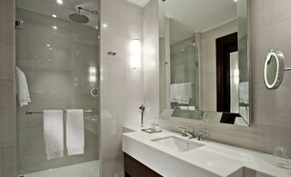 Bathroom of the Marti Istanbul Hotel with white sink, walk in shower and large mirror