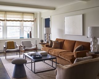 An apartment living room with mid-century Scandinavian furniture and cognac brown velvet sofa