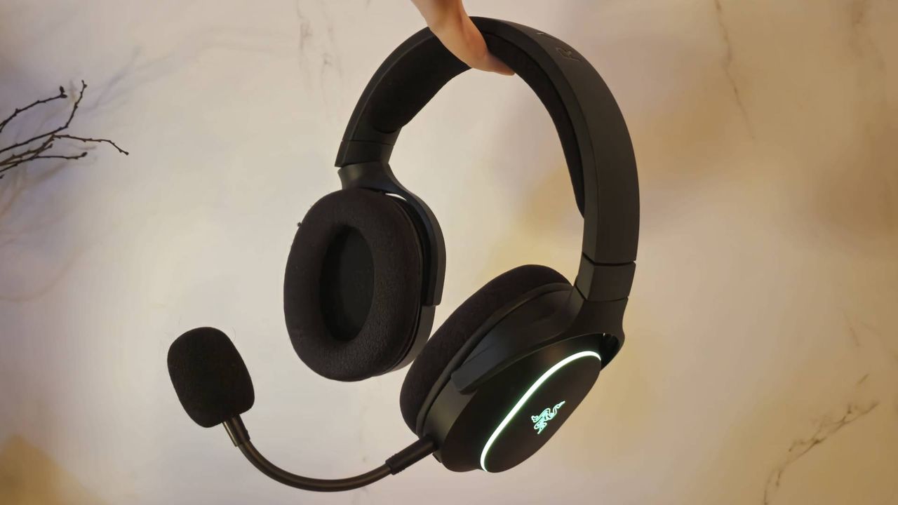 Image of a hand holding up the Razer Barracuda X Chroma headset.