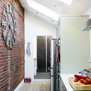 gallery kitchen with brick wall refrigerator and wooden chopping board