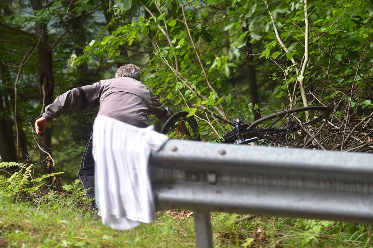 A spectator fishes a rider out of a ditch