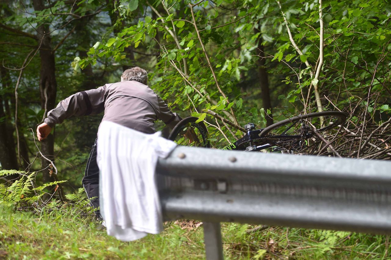 A spectator fishes a rider out of a ditch