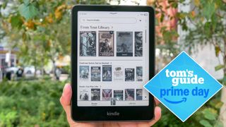 the kindle colorsoft 2024 held up against a green background with trees and and blue tom's guide diamond deal badge