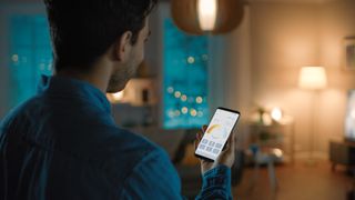 Man using smartphone to control various smart lights in his home