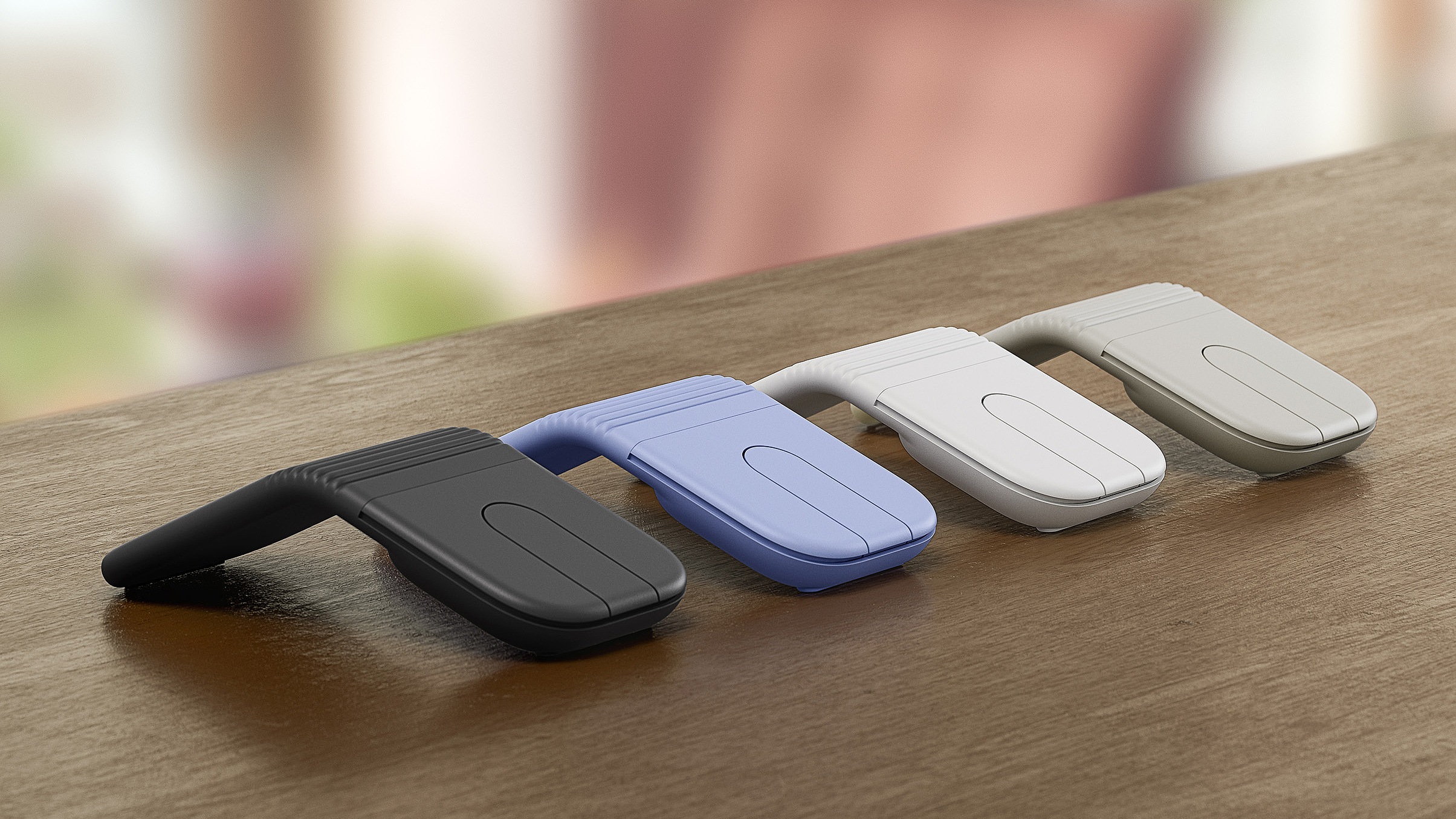 Fire Logitech Mobi Fold-mus i sort, lilla, off-white og beige p&amp;aring; et bord.