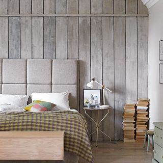 bedroom with wood wallpaper wall and wooden floor and bedside table with lamp
