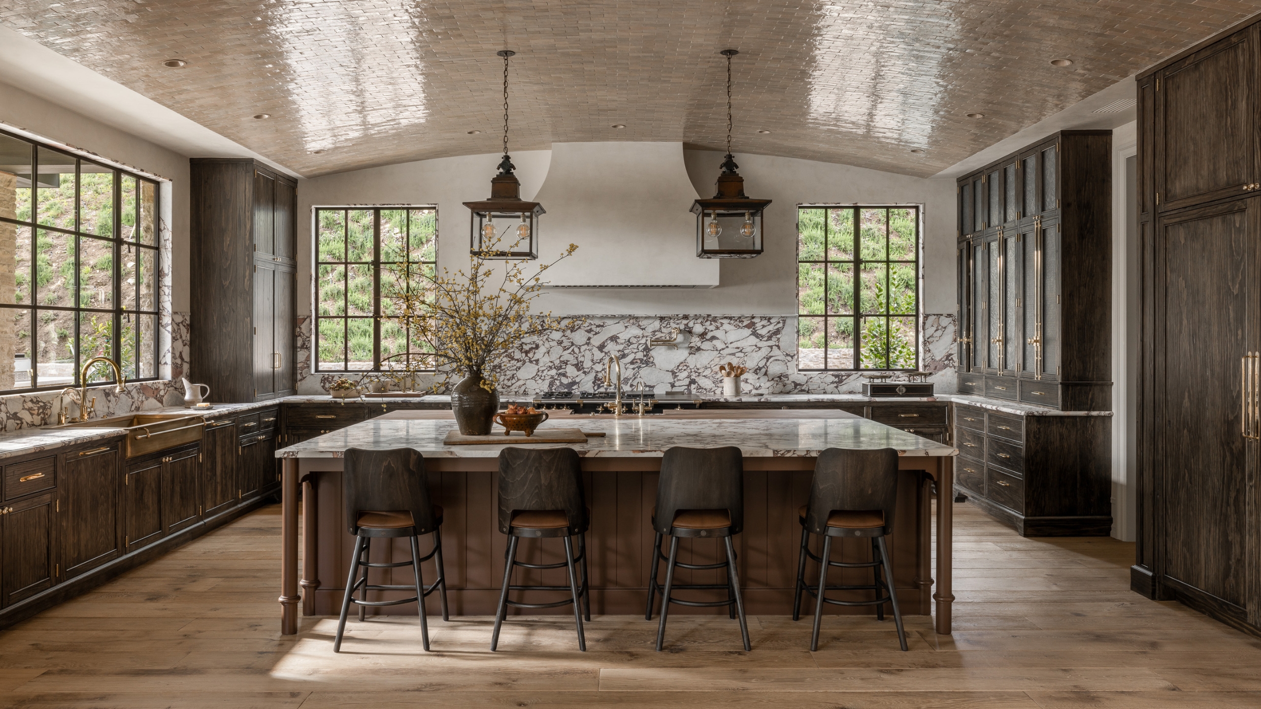 A dark wood kitchens with marble countertops and a curved glossy ceiling