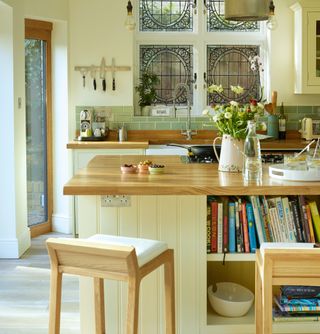Yellow kitchen island with wooden stools