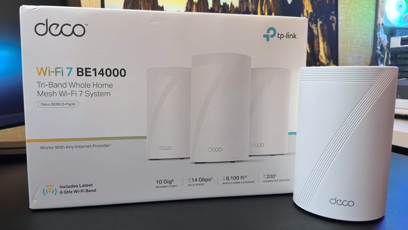 A photo of a TP-Link Deco BE68 mesh router stood next to its retail packaging.