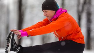 Woman stretching after running in cold weather