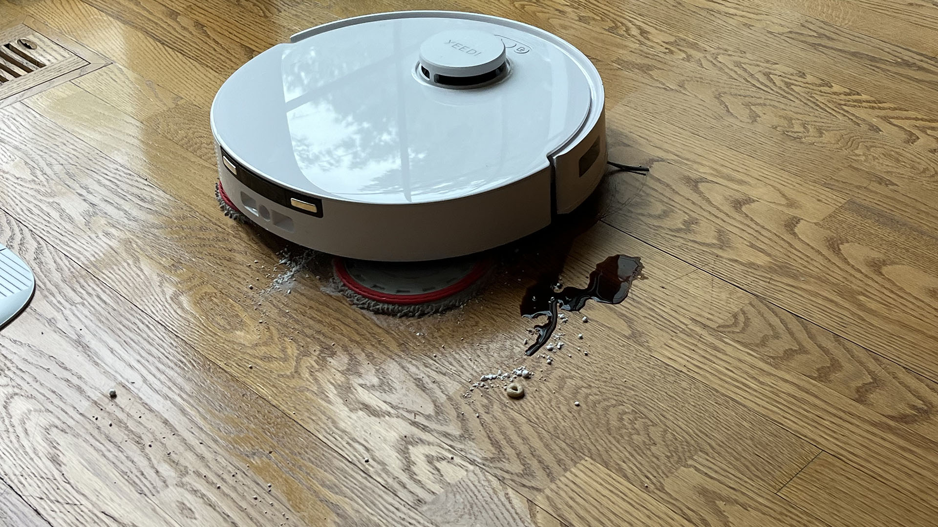 Yeedi M12 Ultra Plus robot vacuum cleaning soy sauce, sugar and cereal from a wooden floor in reviewer's home