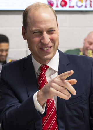 Prince William smiling and pointing at the camera