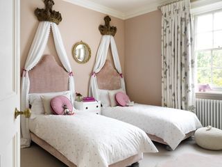 Pink little girl's twin room with coronets above the beds