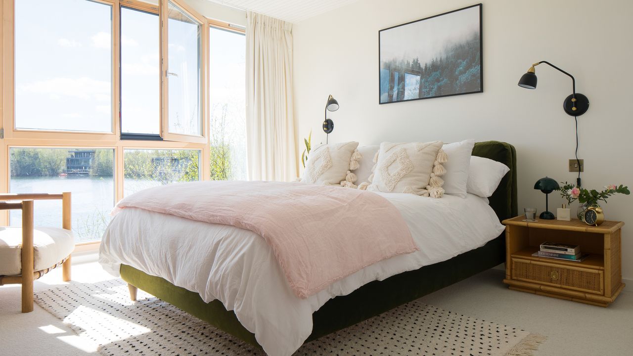 white bedroom with green bed and pink throw