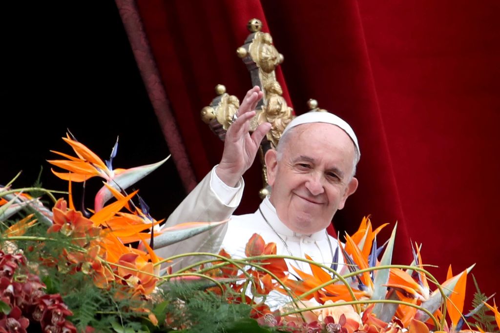 Pope Francis Holds Easter Mass: Pope Francis waves to the faithful, with orange flowers in the foreground, as he delivers his Easter 'Urbi et Orbi' blessing message from the central balcony of St Peter's Basilica on April 21, 2019, in Vatican City, Vatican. 