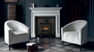 white stone fire surround with two white armchairs