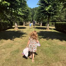 Princess Lilibet, Prince Archie and Prince Harry walking through grass at Althorp