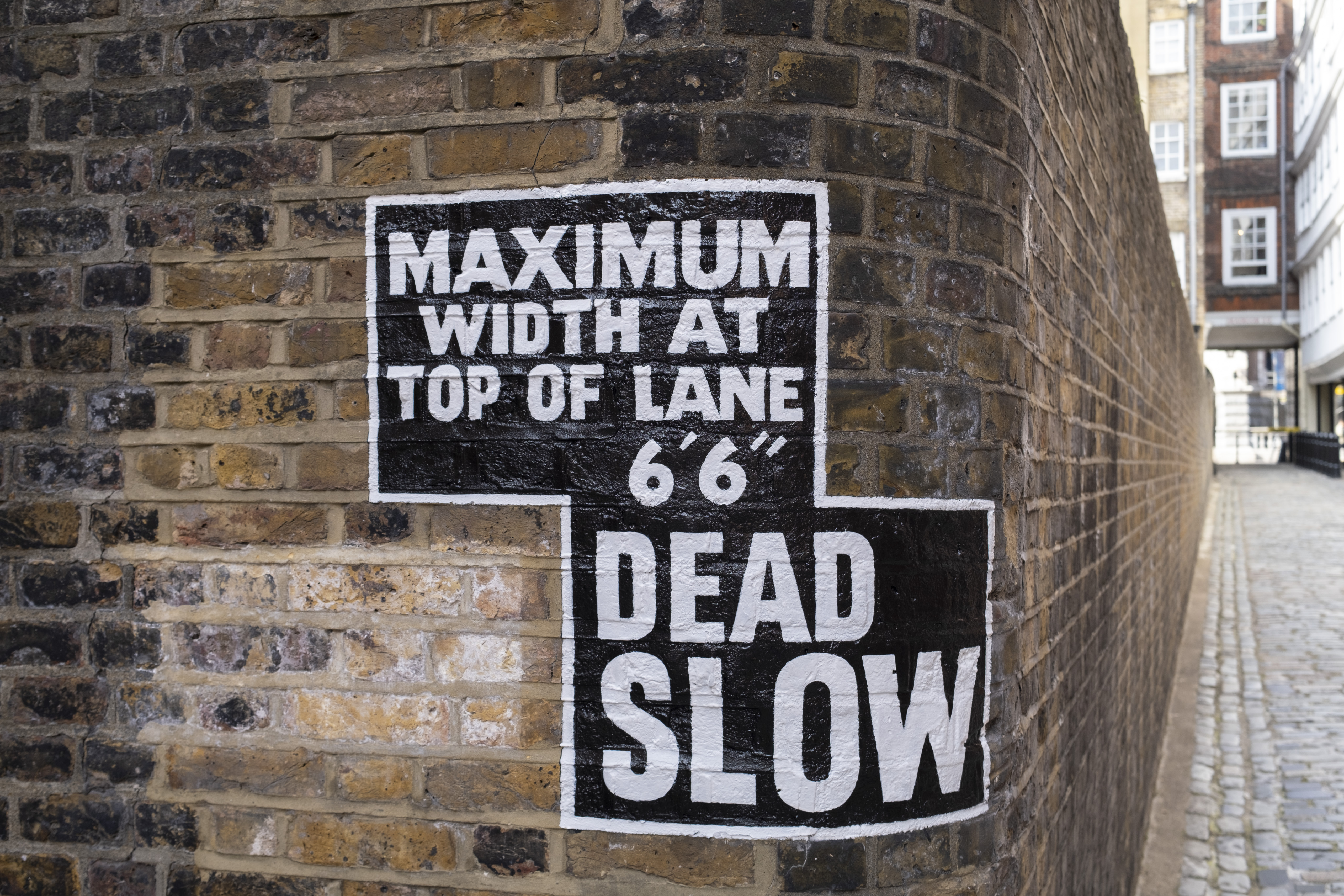 Sign reading dead slow next to cobbled london road