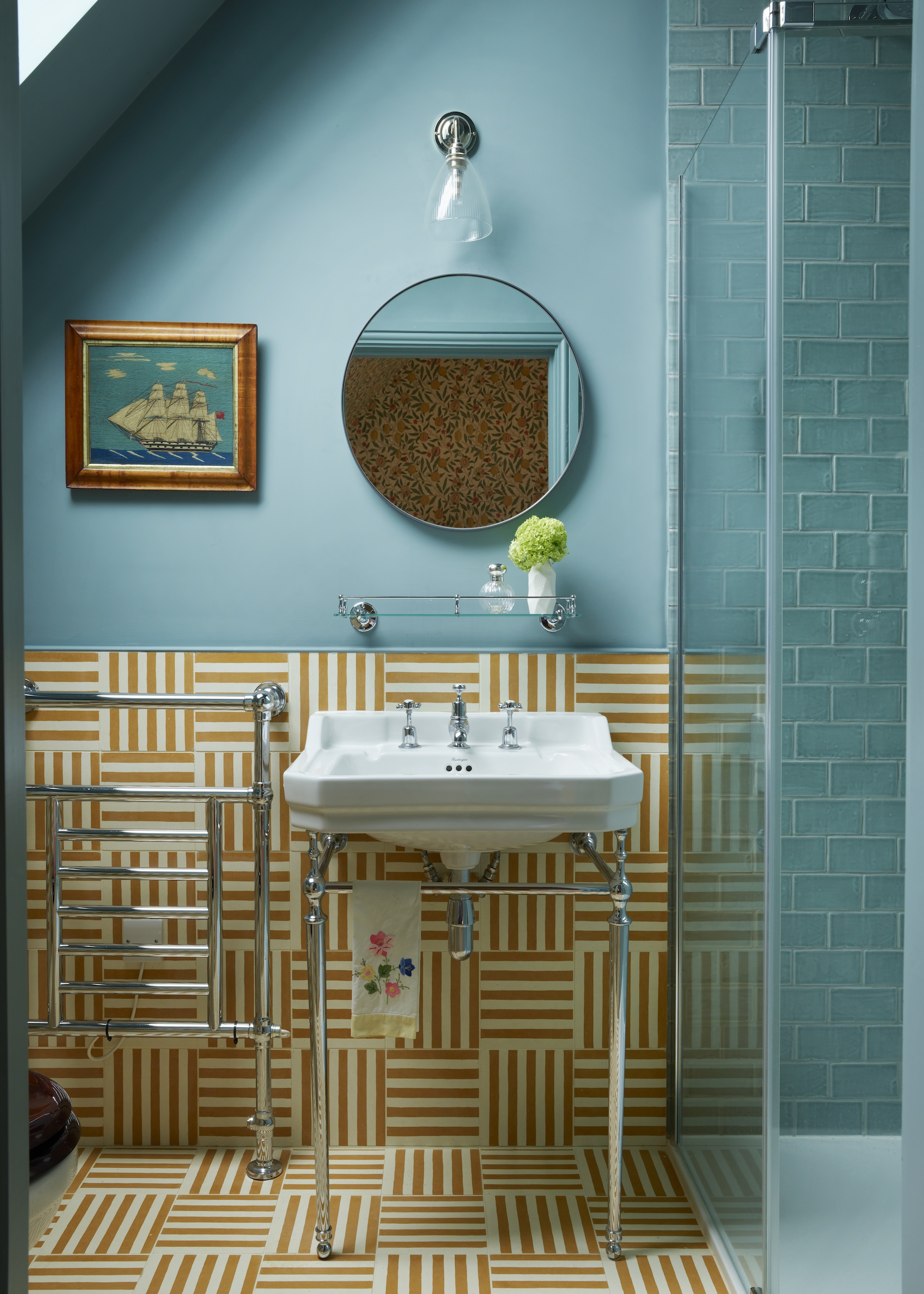 a light blue attic bathroom with colorful striped tiles