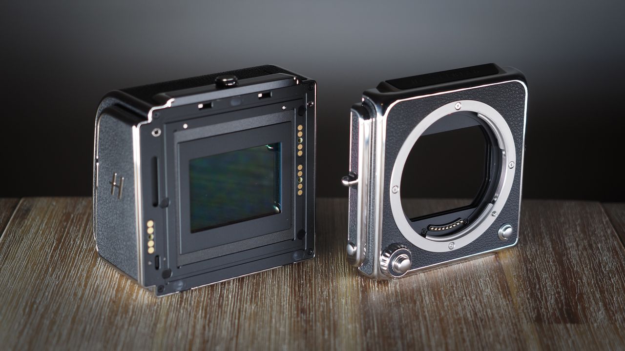 The Hasselblad 907X &amp; CFV 100C medium format camera with digital back, on a wooden table with artistic lighting