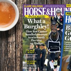 Two copies of Horse & Hound magazine on a wooden table beside a cup of tea