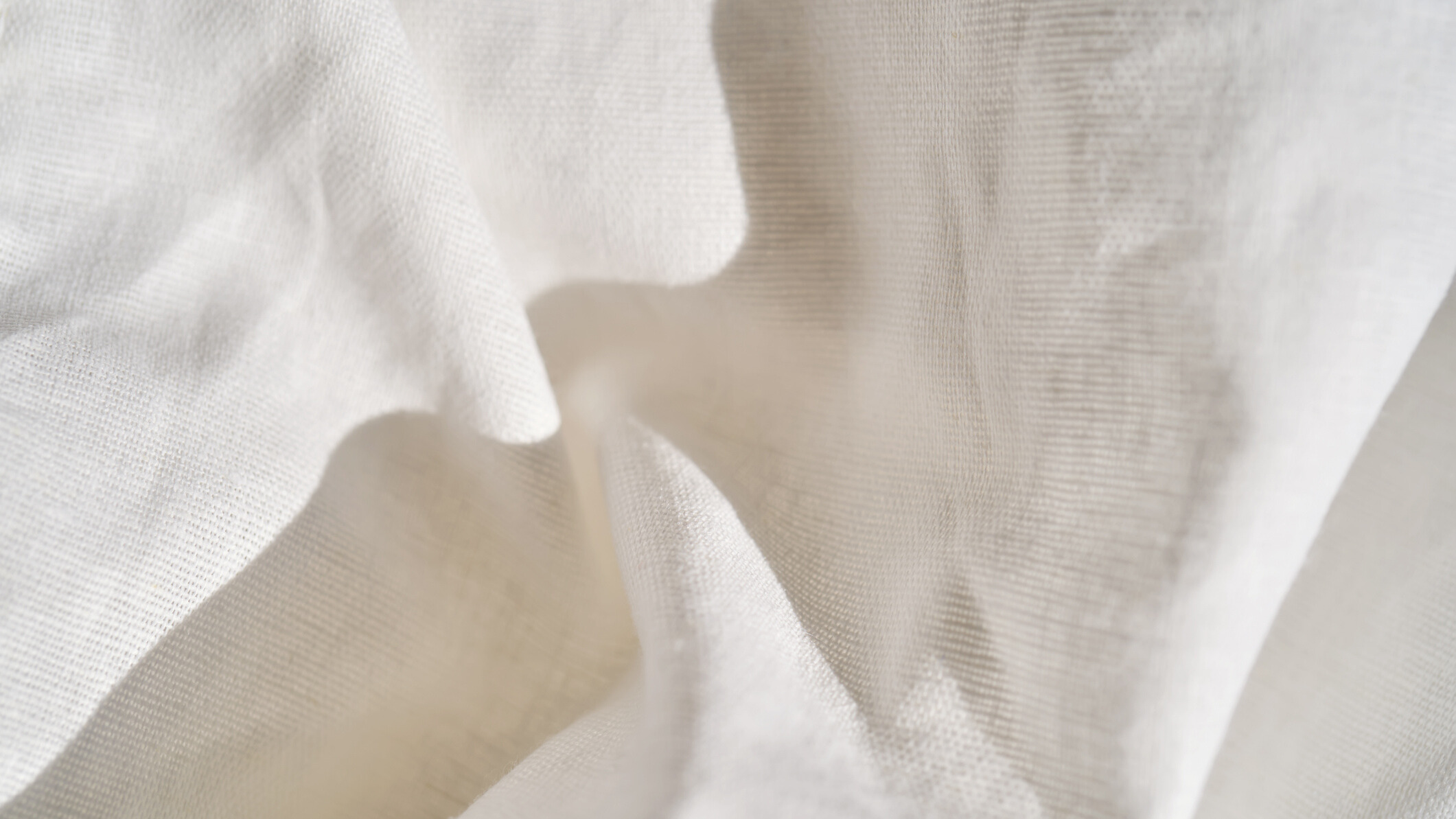 A close-up shot of a white bedsheet showing the fabric details