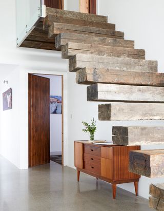 Hallway with exposed wooden staircase and console table