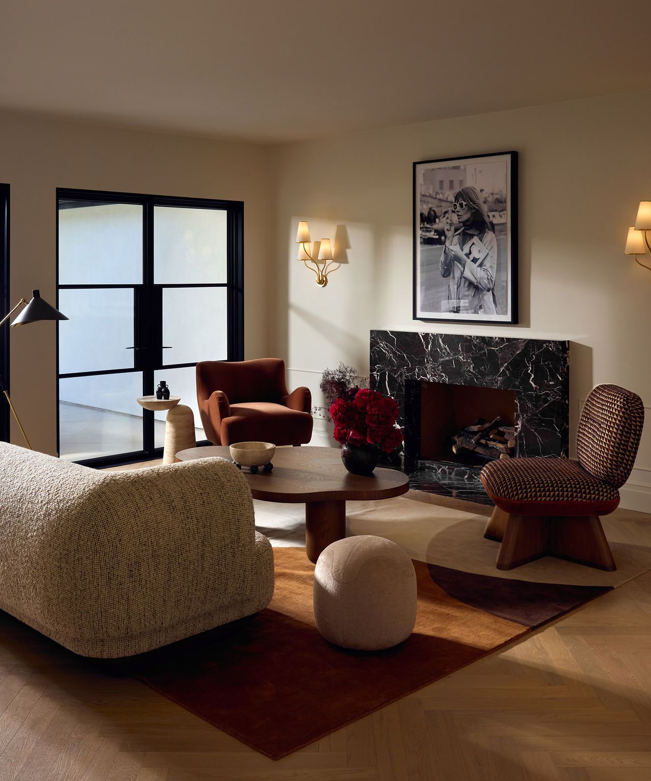 living room with modern, rounded furniture, off-white walls and marble fireplace