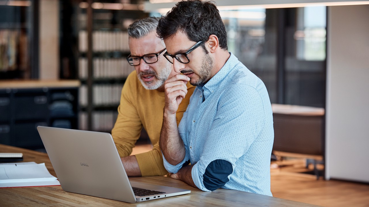 Dell Pro laptop being used by two people at a desk