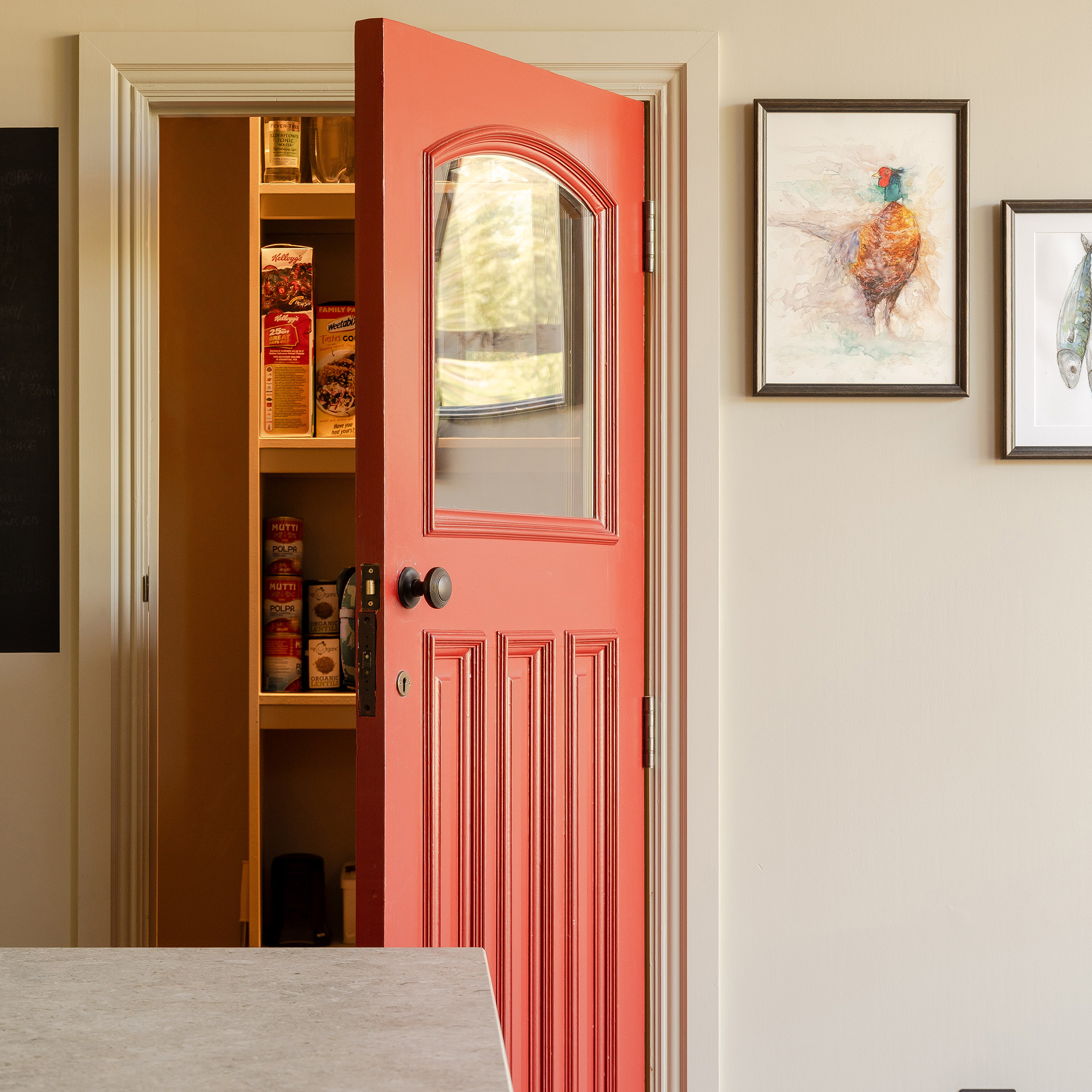 open red pantry door with glass window inside is yellow shelves inside
