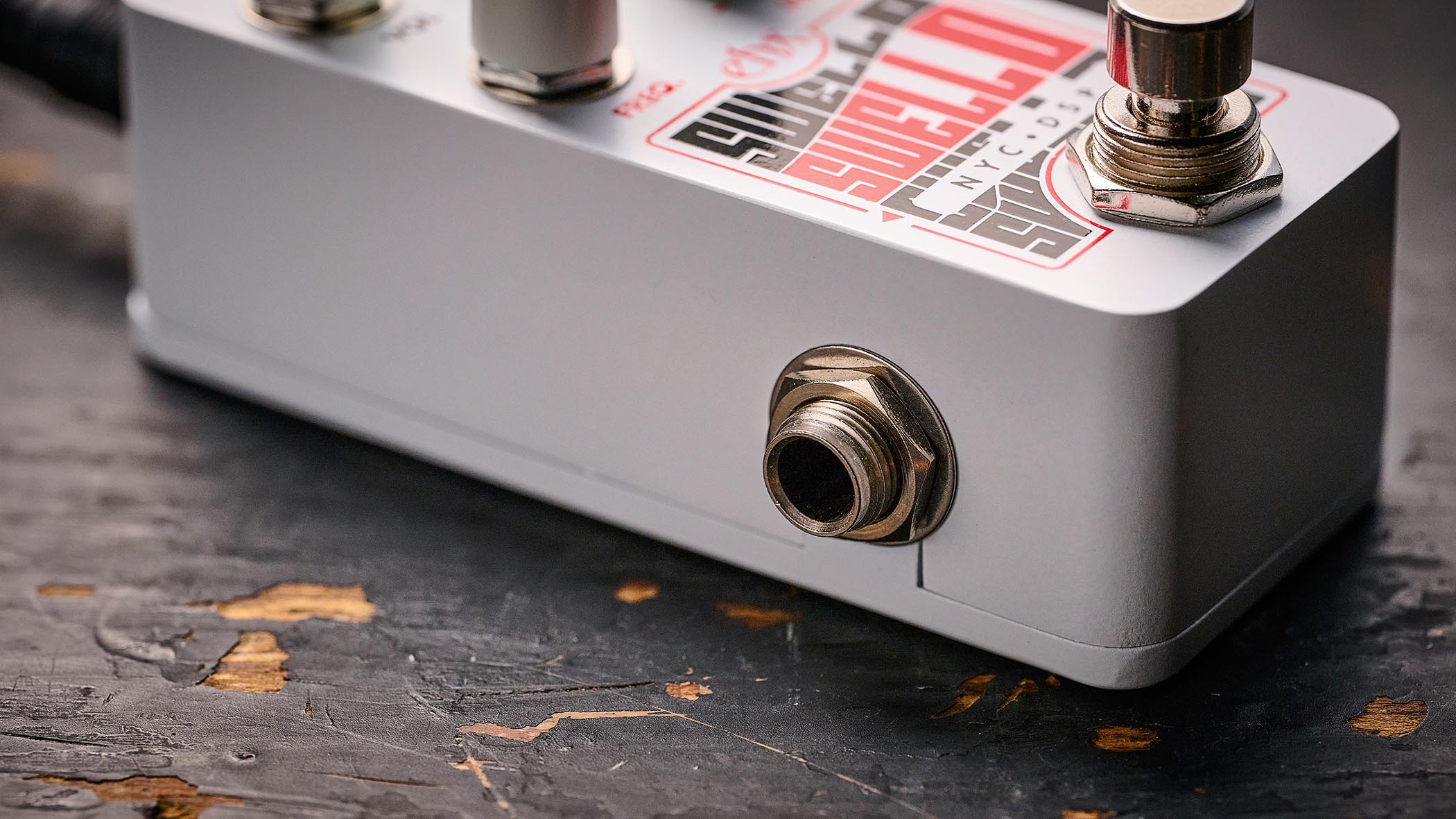 Electro-Harmonix Pico Swello: the compact mini-pedal is finished in white and has black and white text, four knobs, and is photographed against a distressed wood floor.