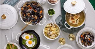 Overhead image of a dining tabel with white linen and the new White Le Creuset cookware collection