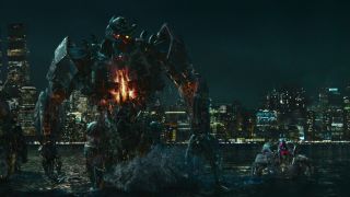 Still from the movie Transformers: Rise of the Beasts. Here we see three dangerous looking Transformers rising out of the water against a nighttime city skyline.