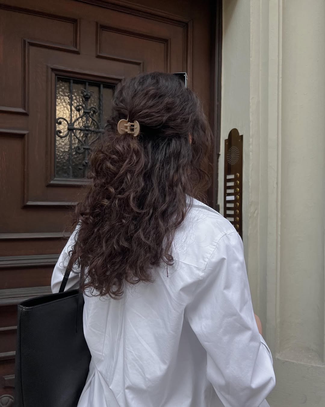 Woman with mid-length hair in a white shirt.