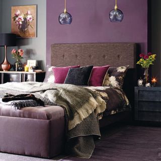 Purple bedroom, double bed with large brown headboard, pendants, dark bedside tables