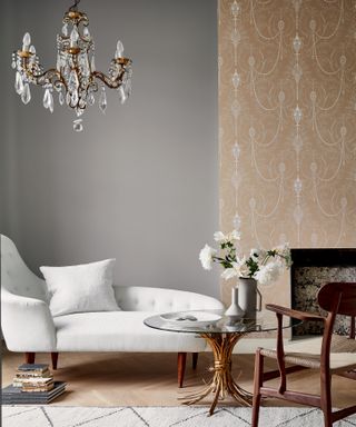 Gray living space with wallpaper on chimney breast and chaise longue in foreground