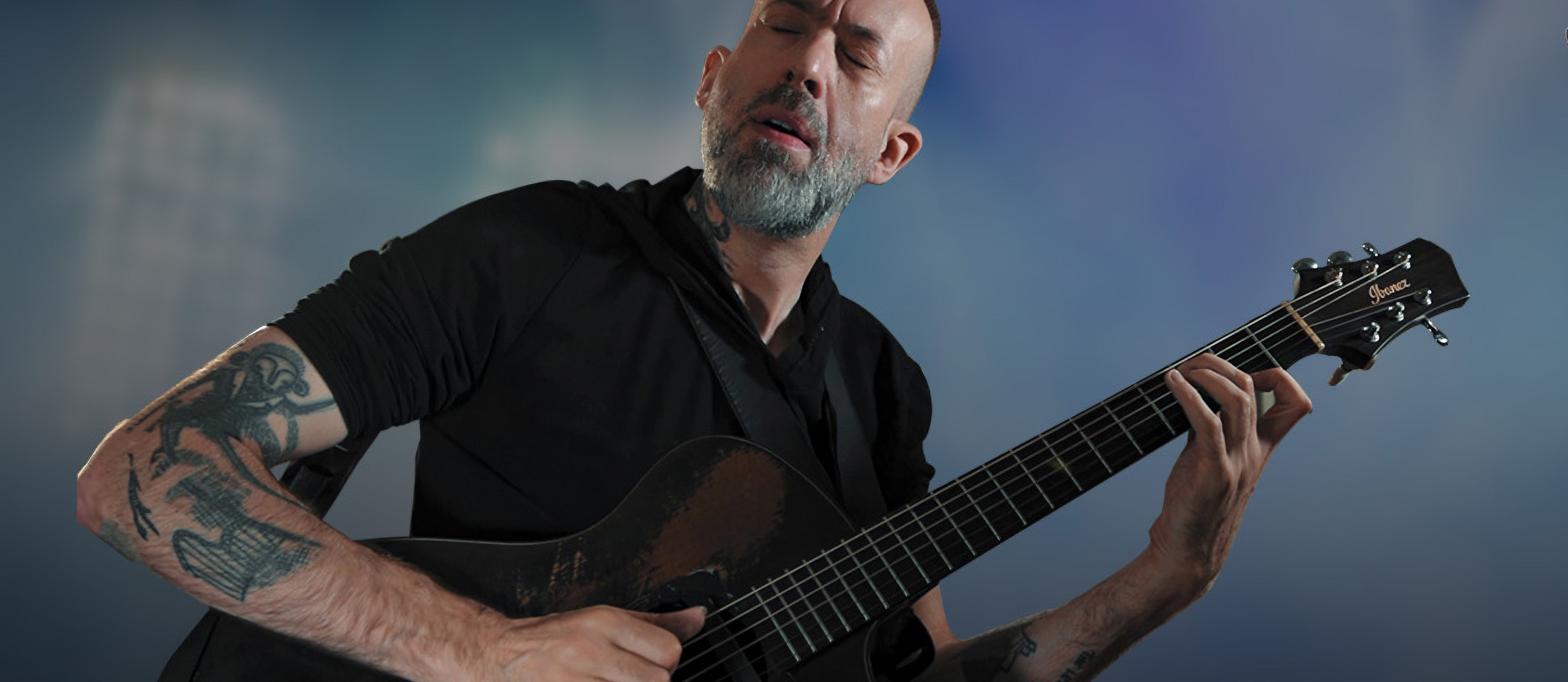 A photo of Jon Gomm playing a guitar equipped with a Fishman Jon Gomm Signature Series Powertap Earth Pro pickup system