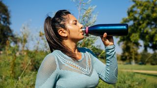 woman drinking from her water bottle