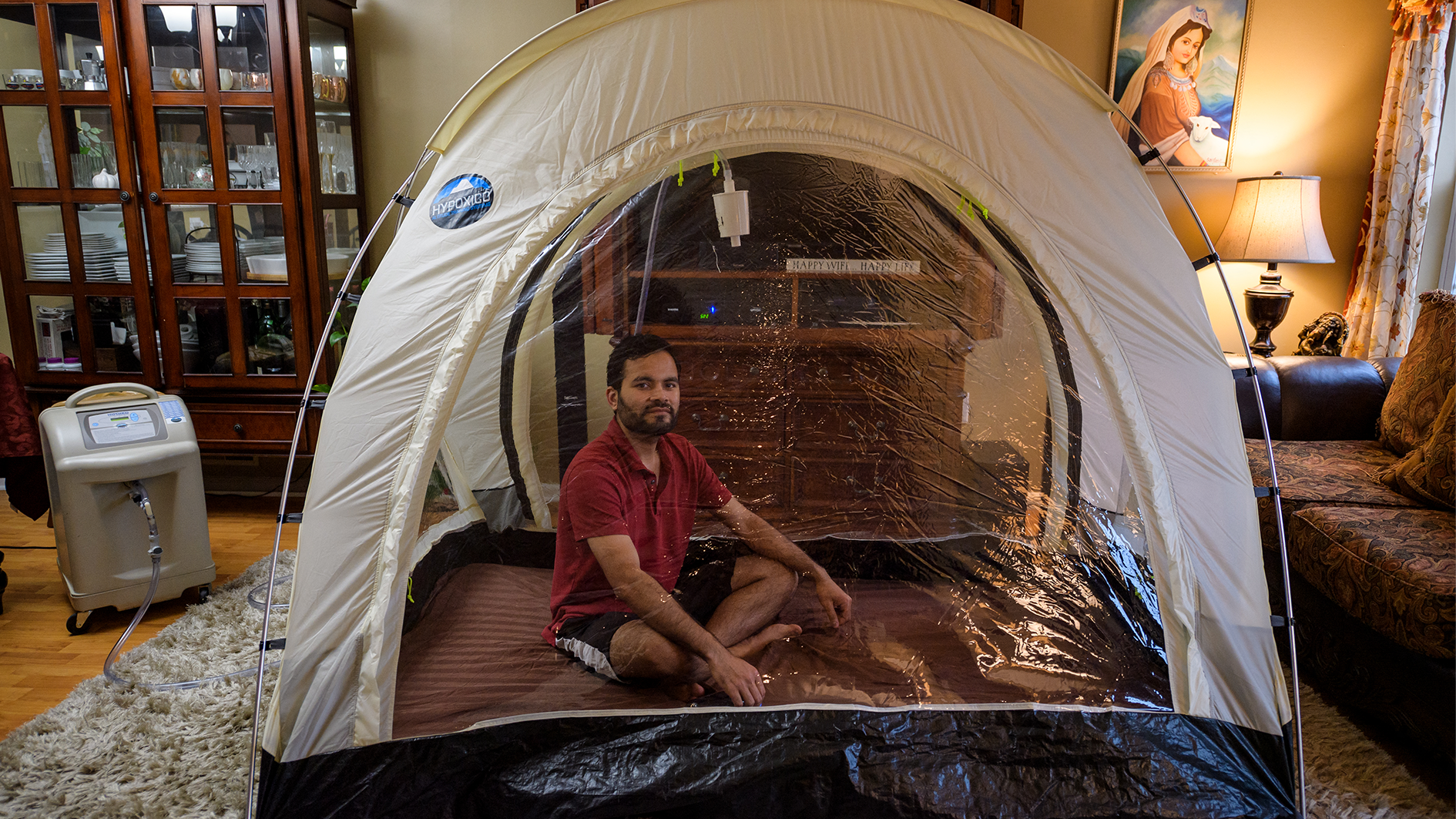 A climber sits in a hypoxic tent