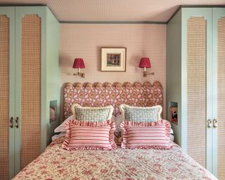 Small guest bedroom with patterned wallpaper and closet on either side of the bed
