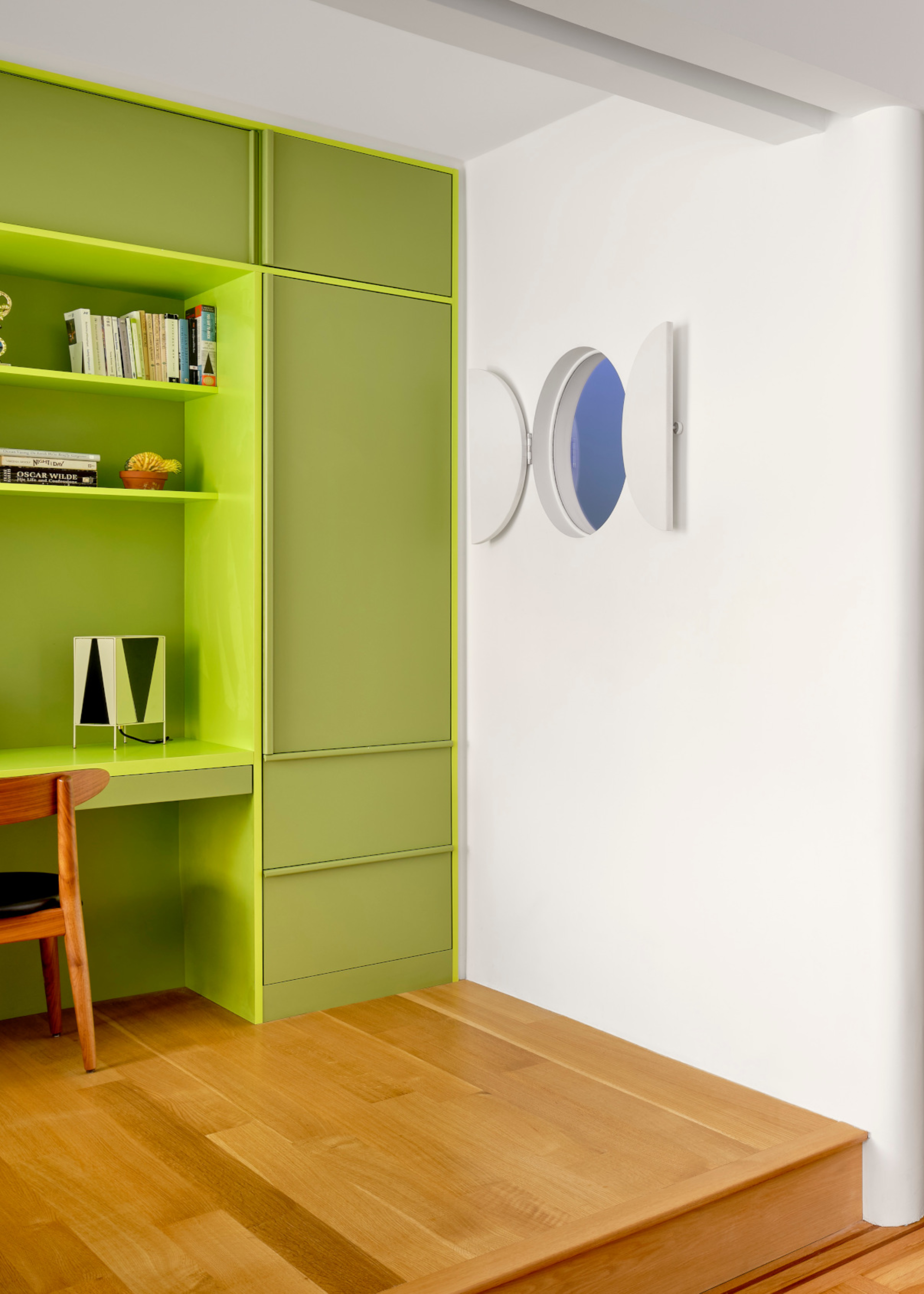 A study with a peridot green work from home space and storage cupboards