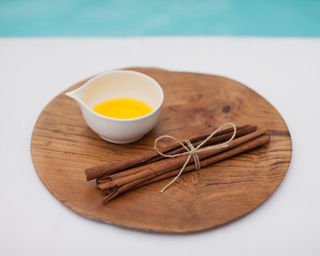 cinnamon sticks with oil on a wooden plate