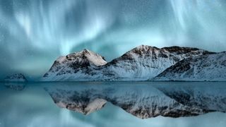 northern lights and snowy mountain reflections