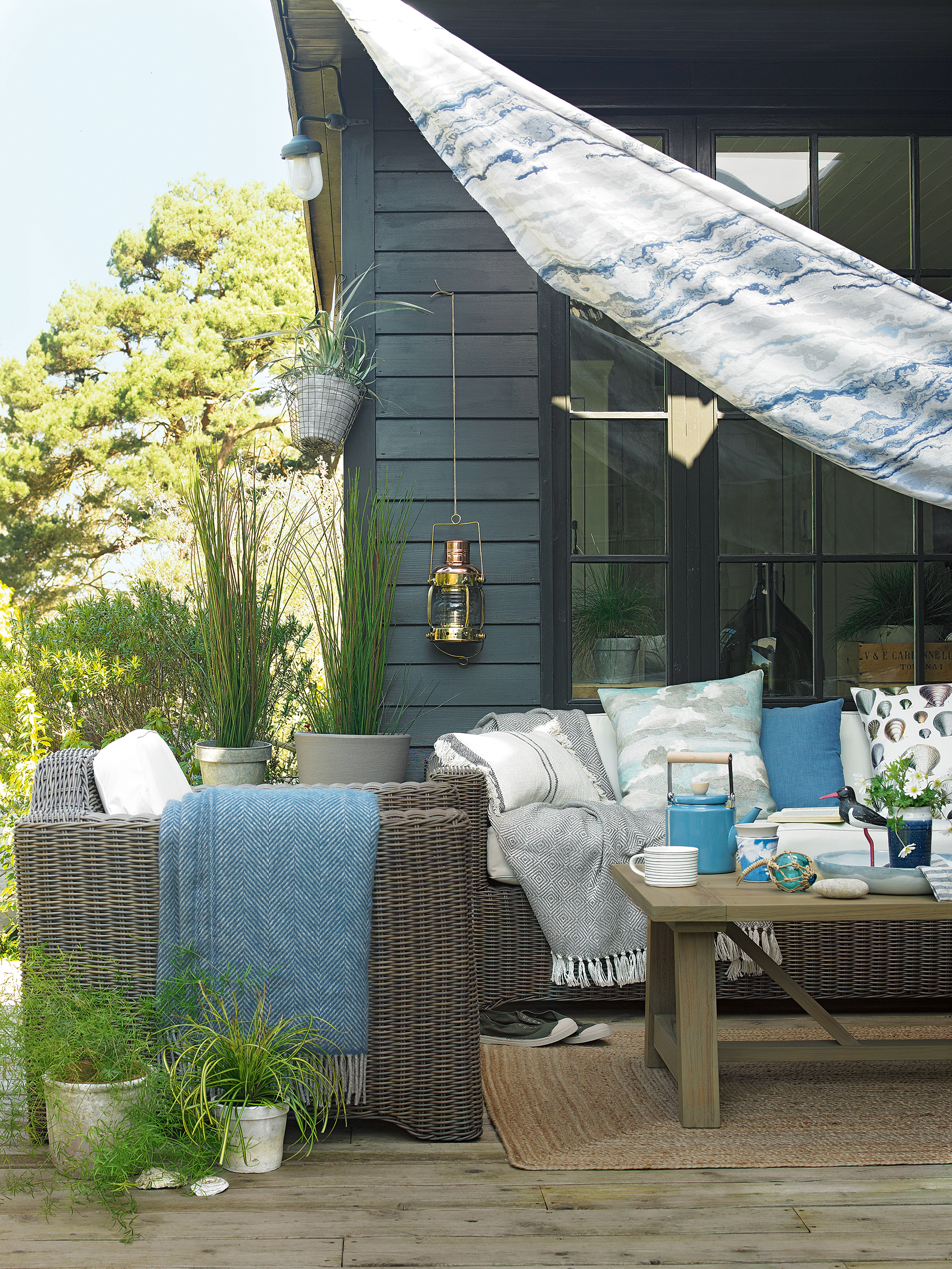 decking with colorful blue sail and garden furniture